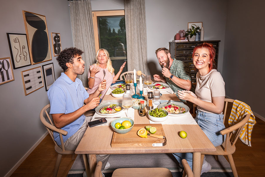 Freunde sitzen gemeinsam am Tisch und essen zusammen