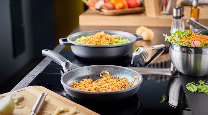 Cadini frying pan 24 cm Onions in the Cadini frying pan 24 cm, in the background the Cadini serving pan and the spaghetti lifter Silicone