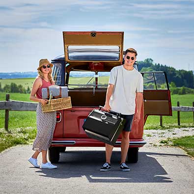 RÖSLE Gasgrill BBQ-Portable Videro G2-P Pärchen beim Picknick. Frau mit Korb und Mann mit Videro G2-P in der Hand.