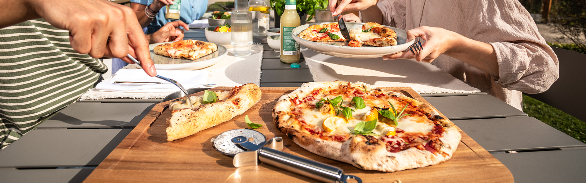 Pizza mit Pizzaschneider auf einem Schneidbrett