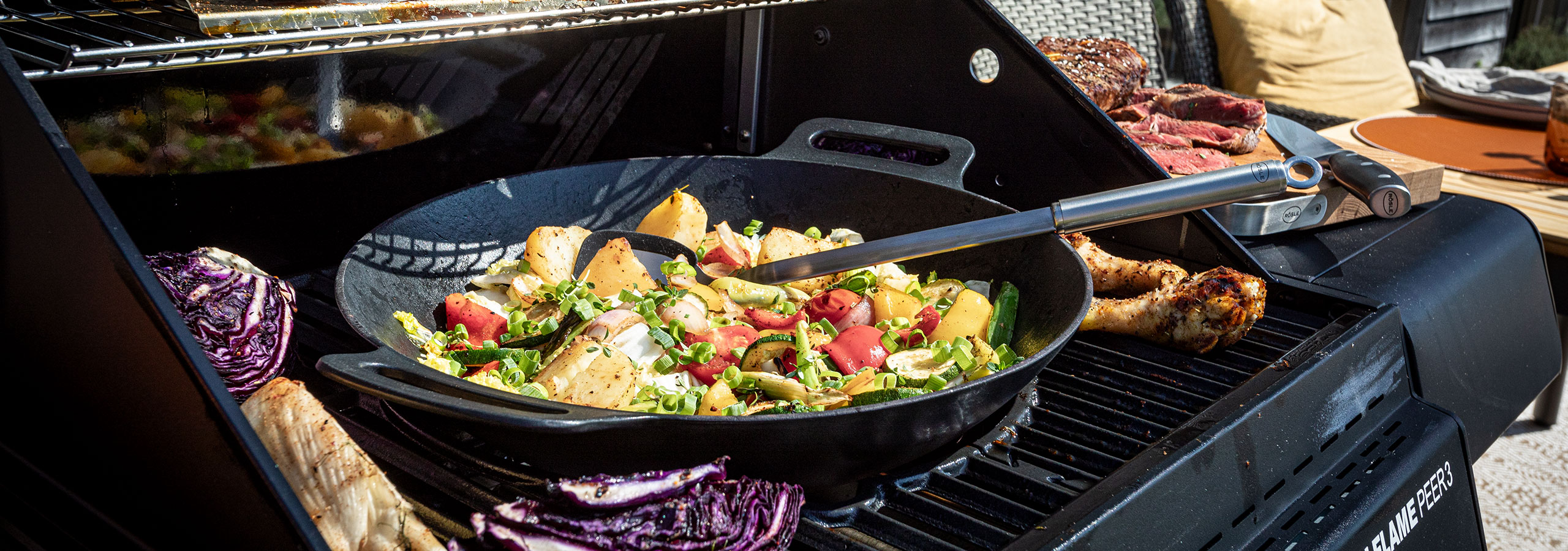 Grillen von Wok-Gemüse in einem Wok auf einem Grill